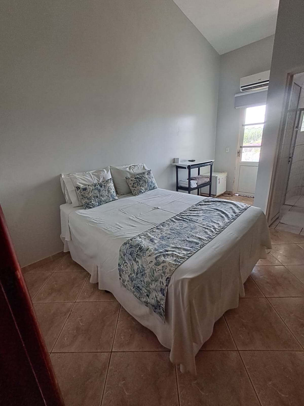 Cama de casal com caminho de cama floral e ar-condicionado